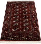 Angled perspective on a vintage Bokhara rug showing its lustrous pile and repeating gul medallions.