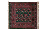 Square vintage Bokhara rug with rows of red and navy gul medallions on a deep green field.