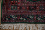 The vintage Bokhara rug's original ivory fringe and intact green selvage.