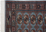 Plush pile, geometric gul motifs, and clean ivory fringe on the corner of a vintage Bokhara rug.