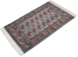 Angled view of a vintage fine Bokhara rug with repeating gul medallions.