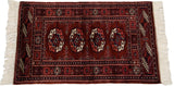 Angled view of a fine Bokhara rug highlighting its plush, lustrous wine-red pile.