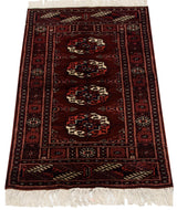 Vintage Bokhara rug from an angle, showing the lustrous pile and repeating gul medallions.