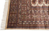 The original full pile and intact side cord selvage on a vintage Bokhara carpet corner.