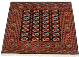 Angled view of a fine Bokhara carpet with a traditional gul pattern and lustrous wool pile.