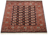 Angled perspective of a vintage Bokhara rug, showcasing its plush wool pile and detailed geometric pattern.