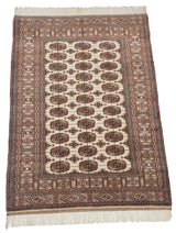 Angled view of a vintage Bokhara rug showing the lustrous, plush pile and repeating gul motif.