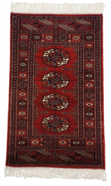 Angled view highlighting the lustrous cherry red pile of a vintage fine Bokhara rug.