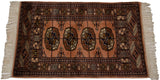 Bokhara rug’s intricate border patterns and geometric gul medallion on a dusty rose field.