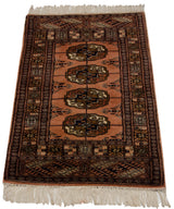 Finely woven gul medallions and geometric borders on the plush dusty rose Bokhara rug.