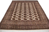Angled view of a lustrous vintage Bokhara carpet showing its rows of geometric gul medallions.