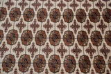 A detailed view of the repeating gul medallions in a tight, fine weave on a plush wool carpet.
