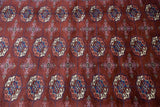 Fine, plush Bokhara wool pile revealing detailed repeating gul medallions in wine red and indigo.