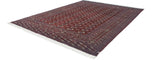 Hand-knotted vintage Bokhara rug corner with ivory fringe and geometric wine red border.