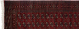 The plush, full pile and intricate geometric border of a vintage cherry red Bokhara rug runner.