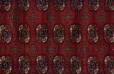 Finely woven gul medallions in cherry red, navy blue, and ivory on a vintage Pakistani Bokhara rug.