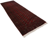 Diagonal view of a vintage cherry red Bokhara runner with columns of geometric gul medallions.
