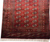 Detailed geometric terminal border and clean ivory fringe on a cherry red vintage Bokhara runner.
