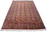 Dusty rose vintage Bokhara carpet end with geometric borders and full white fringe.