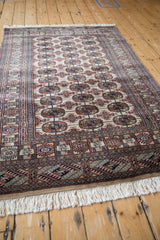 Fine Bokhara rug from an angle, showing the lustrous pile and repeating gul pattern.