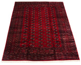 Angled view of a vintage Bokhara carpet showing the high sheen on its cherry red pile.