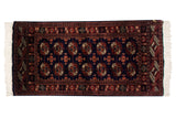 Vintage hand-knotted Bokhara rug with repeating gul medallions in chestnut rust and ivory on a navy blue field.
