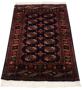 Angled view of a vintage fine Bokhara rug, highlighting its lustrous navy pile and geometric gul design.