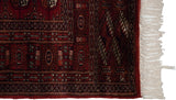 Detailed view of the soft, silk-like pile and secured ivory fringe on a vintage Bokhara runner.