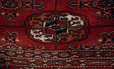 Close-up of the dense, plush pile showing a geometric gul medallion in red and navy blue.