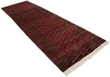 Full-length angled view of a vintage Bokhara runner with its lustrous cherry red field and geometric gul motif.