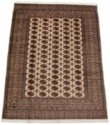 Angled view of a vintage Bokhara carpet highlighting the lustrous pile and repeating gul design.