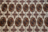 Intricate, finely knotted gul medallions in bronze and navy blue on a plush Bokhara carpet.
