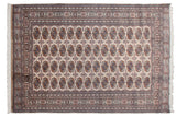 Detailed geometric border and repeating Bokhara gul medallions in beige and navy.