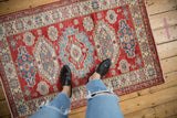 Pakistani Caucasian rug with cherry red field, indigo blue geometric soumac medallions.