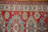 Cherry red geometric Caucasian rug with stepped medallions and indigo blue motifs.