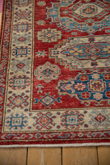 Geometric ivory border meets cherry red Caucasian design field with short fringe.