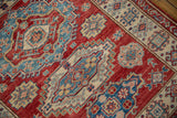 Cherry red field with intricate indigo blue, ivory, and beige geometric floral motifs.