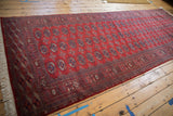 Full length view of a fine Bokhara runner with its repeating red and navy blue gul motif.