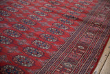 Lustrous red wool pile and fine weave of a vintage Bokhara runner with repeating gul medallions.