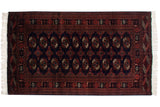 A traditional Pakistani Bokhara rug with repeating elephant footprint guls on a rich navy blue field.