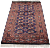 Full length perspective of a fine vintage Bokhara rug with its navy blue field and repeating gul medallions.
