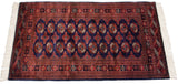 Angled view of a fine Bokhara rug showing its lustrous wool pile and repeating gul pattern.