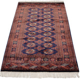 Plush wool pile, geometric end border, and white fringe on a vintage Bokhara rug.