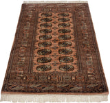 Vintage Bokhara rug featuring intricate geometric side borders and repeating gul medallions in dusty rose and navy.