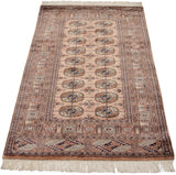 Vintage Bokhara rug showing intact cream fringe, intricate geometric borders, and gul medallions.
