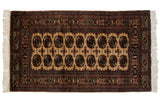 Fine vintage Bokhara rug with traditional gul medallions on a camel field and intricate navy borders.