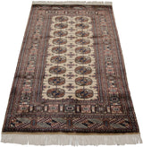 Vintage fine Bokhara rug from a lengthwise angle, showing its lustrous wool pile and repeating gul pattern.