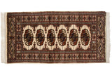 Vintage Fine Bokhara rug runner with repeating gul medallions in navy, bronze, and copper on an ivory field.