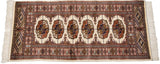 Finely woven corner of a vintage Bokhara rug showing the plush wool pile and intricate geometric borders.