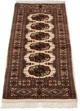 Lengthwise view of a vintage Bokhara rug runner with plush pile and geometric gul designs.